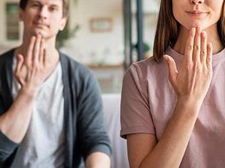 Front view of couple communicating with sign language.